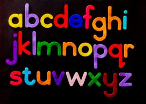 Vibrant alphabet letters arranged against a dark background for educational use.